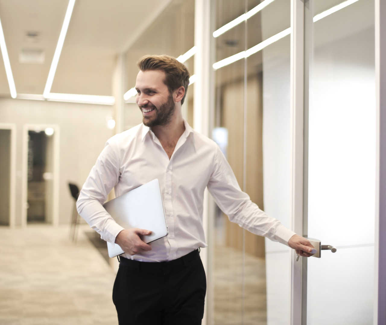 men smiling, opening a door